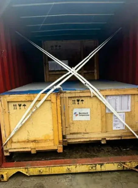 Wooden equipment crates secured with straps inside a container