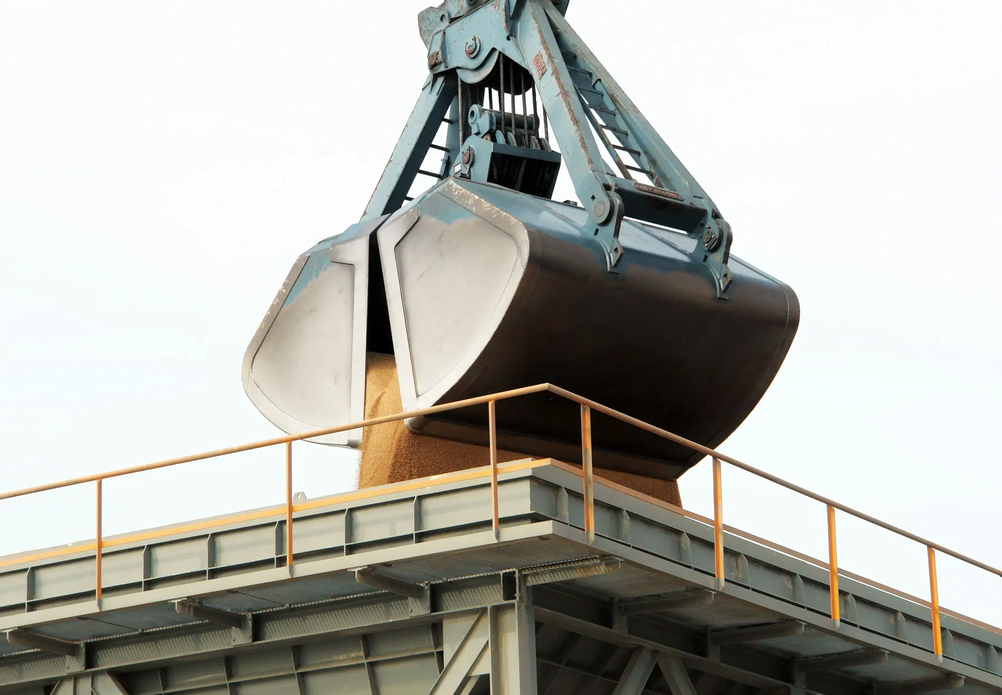 Clamshell grab unloading bulk cargo at a port terminal